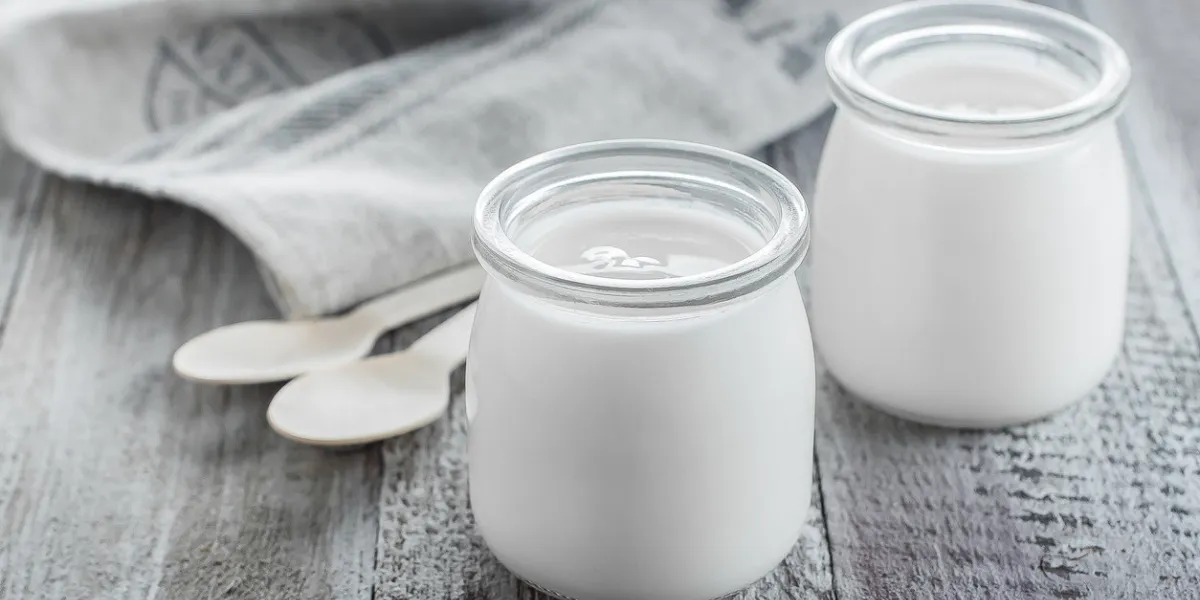 greek yogurt in a glass jars with wooden spoons on wooden background healhty breakfast food copy space