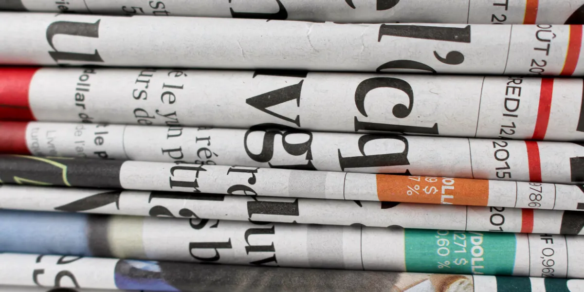 this is a photograph of newspapers stacked one on the other