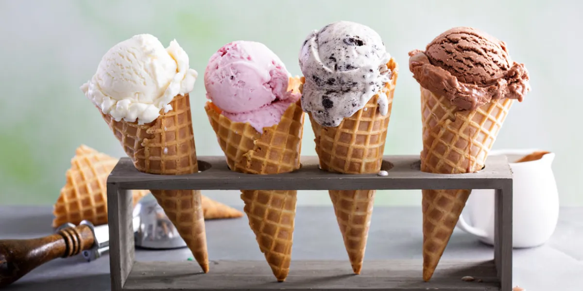 variety of ice cream scoops in cones with chocolate, vanilla and strawberry