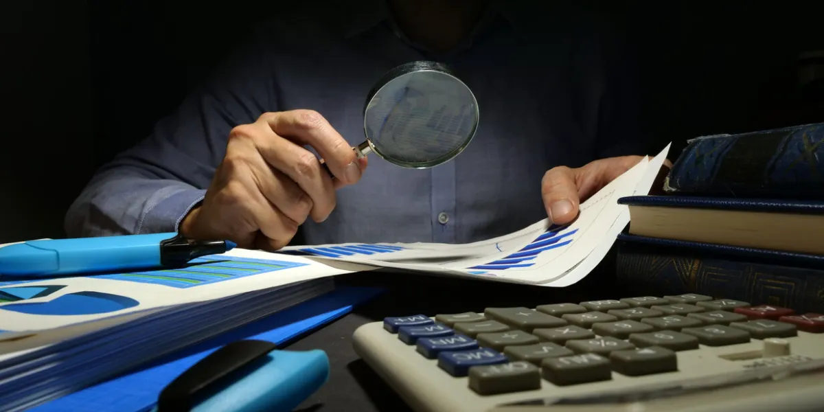 auditor checks financial report with magnifying glass internal audit and business analysis