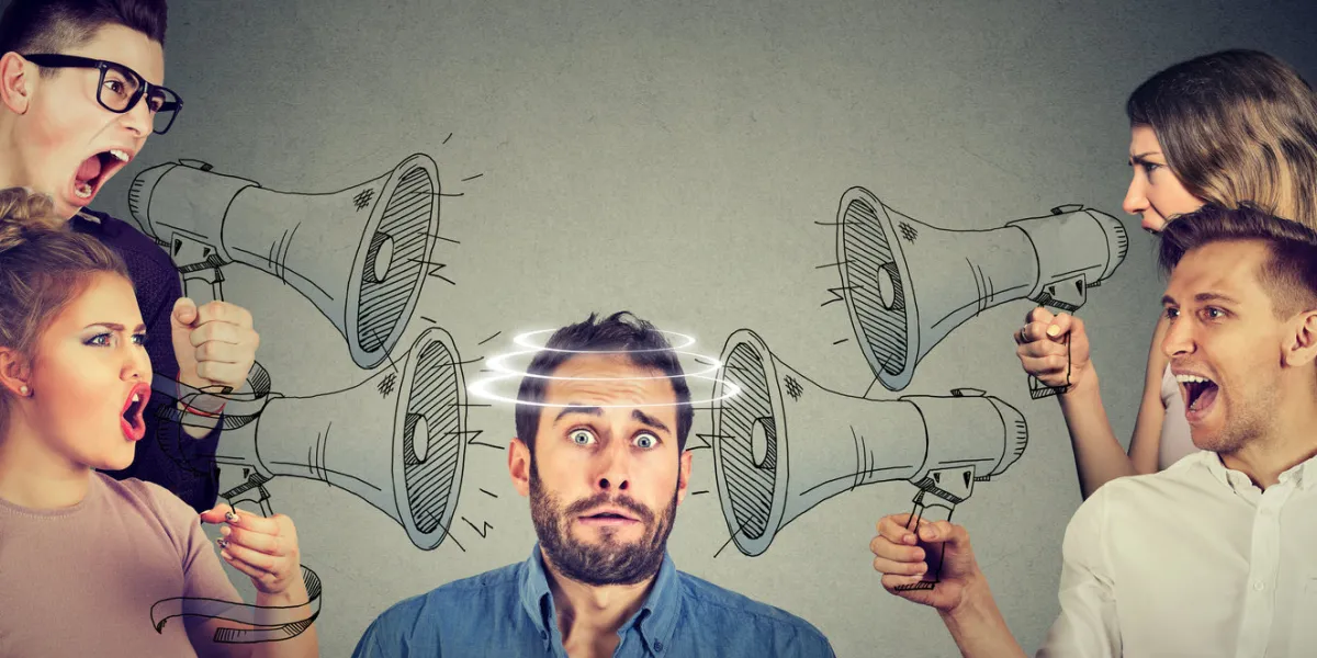 group of people screaming in megaphones at scared guy