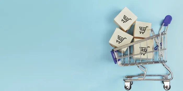 boxes in a shopping cart on blue background concept  online shopping, e commerce and delivery of goods copy space