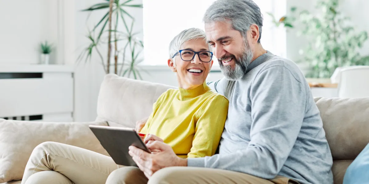 portrait of happy smiling senior couple using tablet at home
