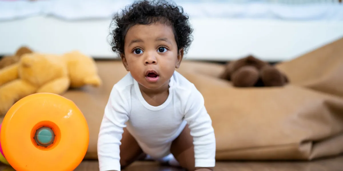happy african american little baby boy crawling and looking for some thing to learn
