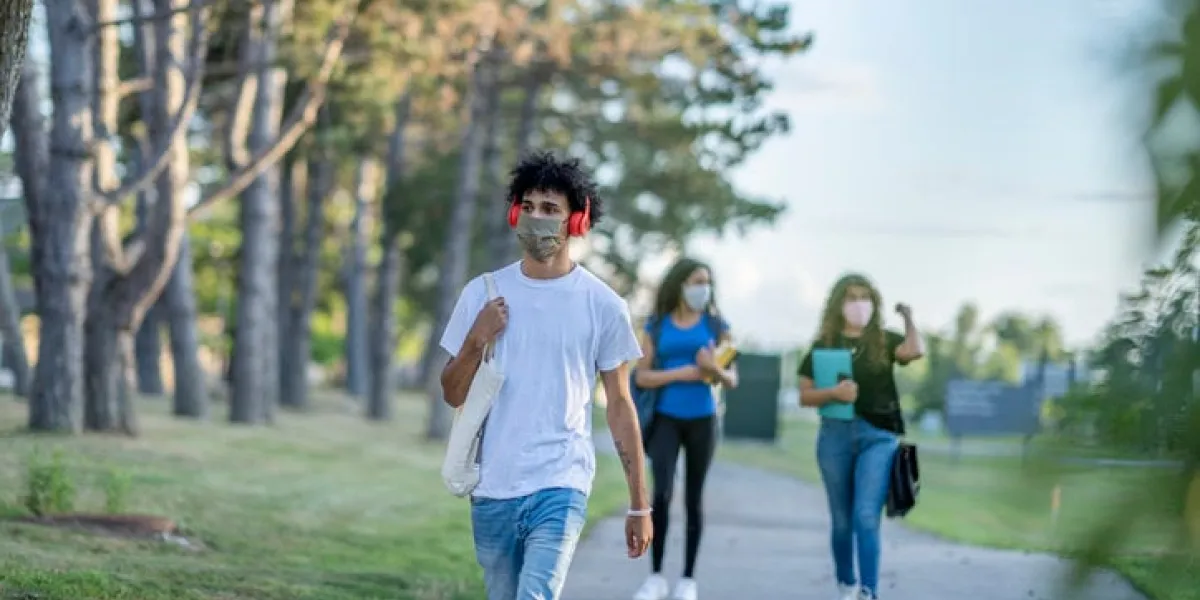 group of students wearing reusable face masks while walking together on campus