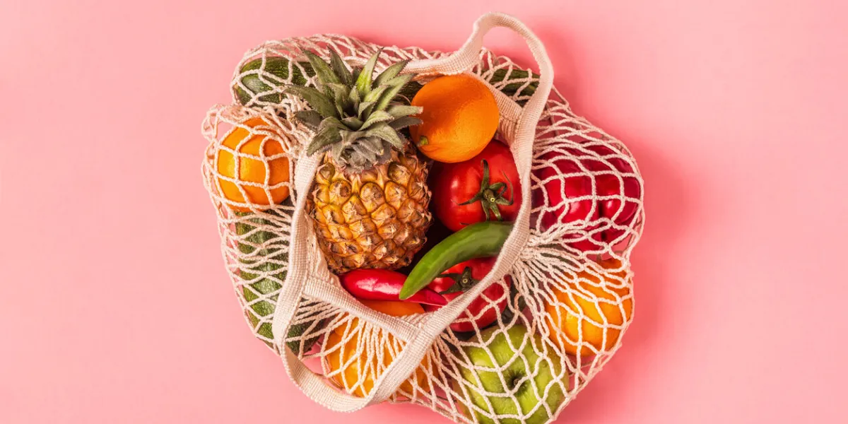 fresh vegetables and fruits in bag mesh, top view