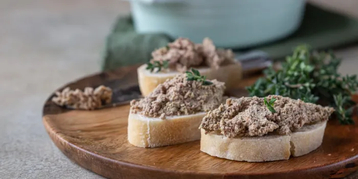 ciabatta with chicken or turkey liver pate with thyme, concrete background selective focus