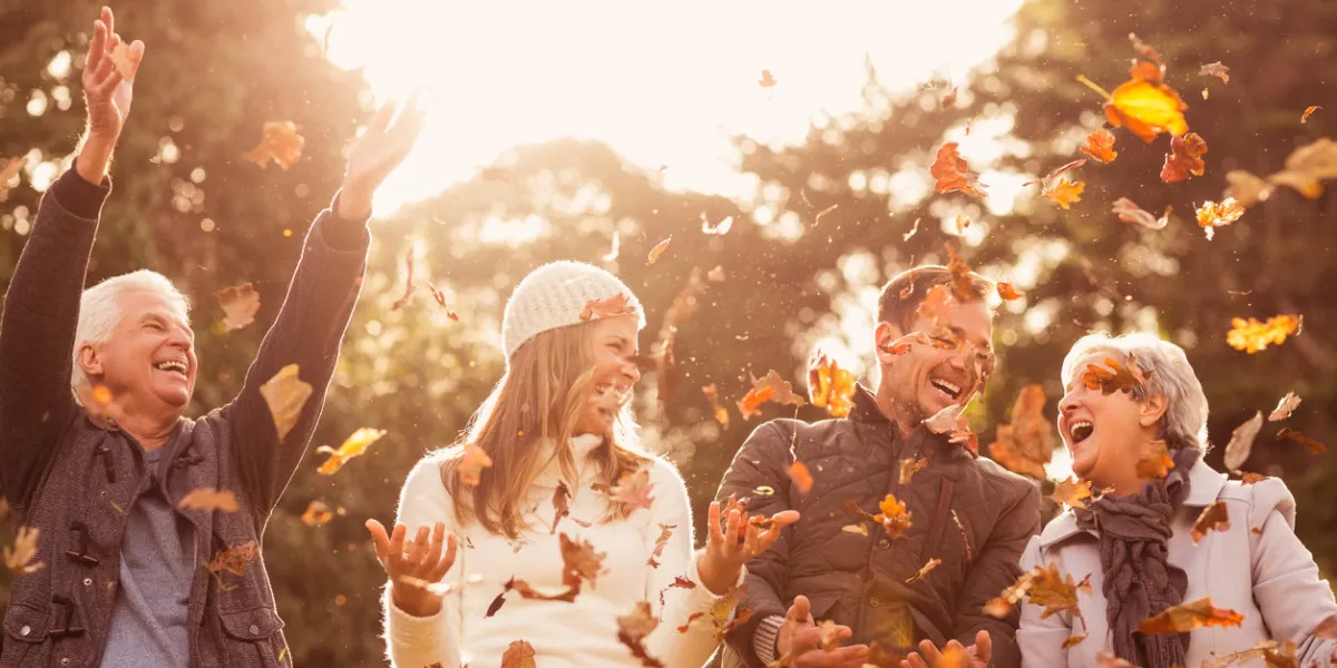 happy family throwing leaves around on an autumns day