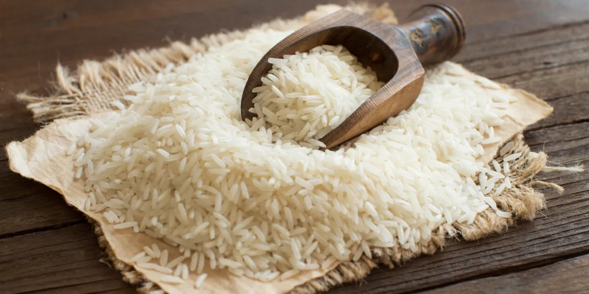 pile of raw basmati rice with a spoon close up