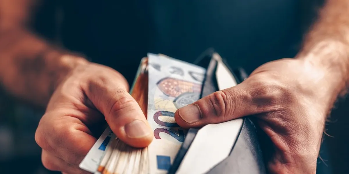 stack of euros in a wallet - purchasing power - male hands closeup