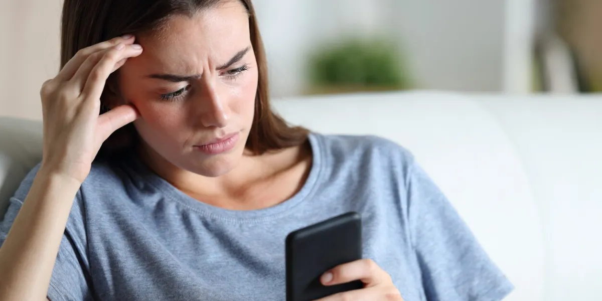 worried girl checking smart phone at home
