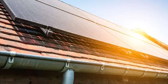 close-up of dusty solar panels on roof of pool house against blue sky with sunshine alternative energy source dirty solar panels covered with sand during dry hot summer