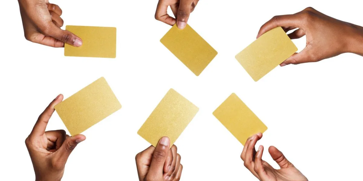 set of african-american man's hands holding golden empty business or credit cards with copy space isolated at white background