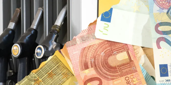 euro banknotes and petrol pump at the petrol station