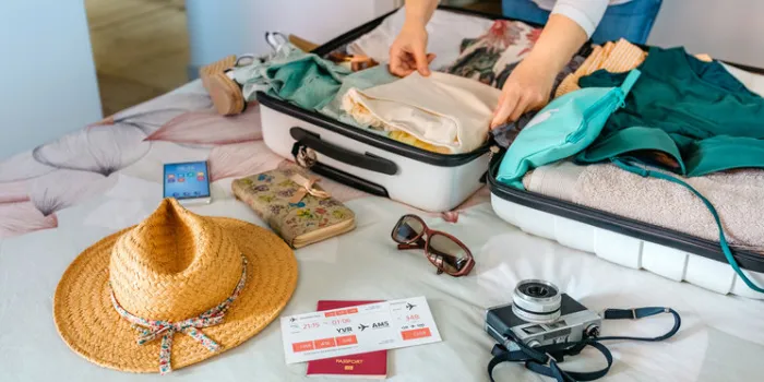 unrecognizable woman preparing suitcase for summer holidays on the bed