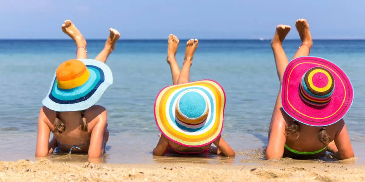 filles avec des chapeaux colorés sur la plage