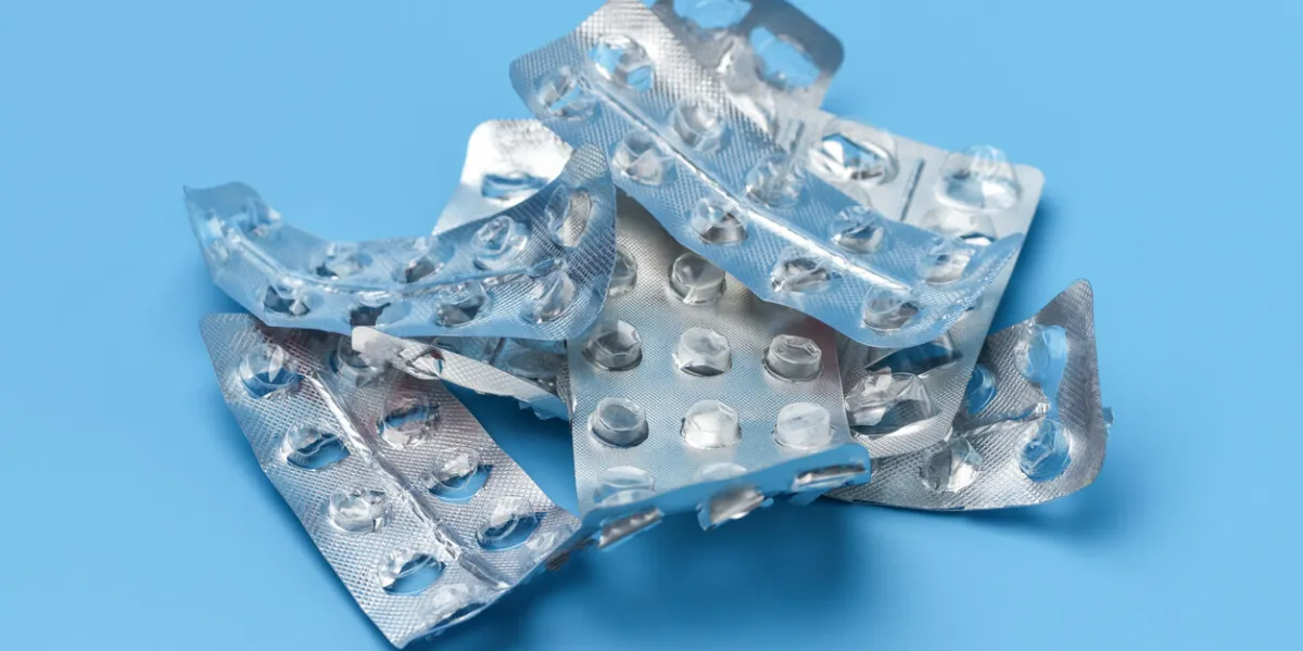 lots of empty pill packs on a blue background medical background
