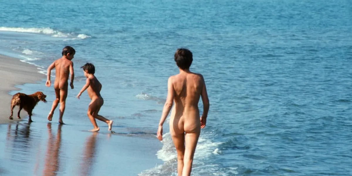 une femme et deux enfants marchent nus sur la plage naturiste de port leucate, en juin 1976   afp photo