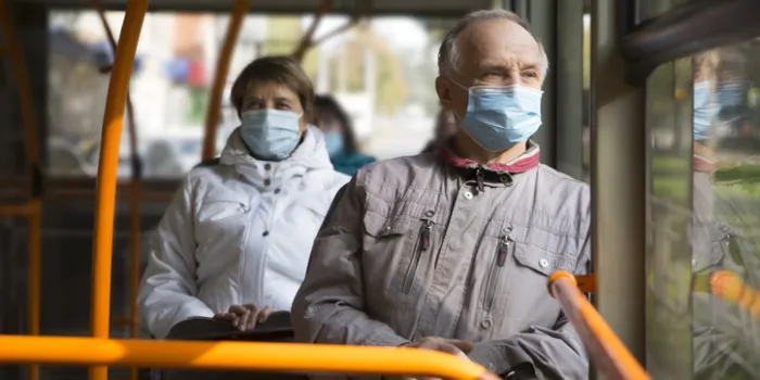 senior man wearing medical face mask sitting in the bus transport