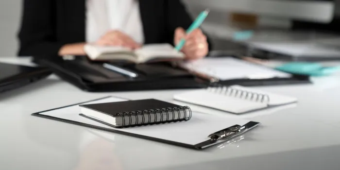 cropped image of businesswoman working in office, supplies on tabletop