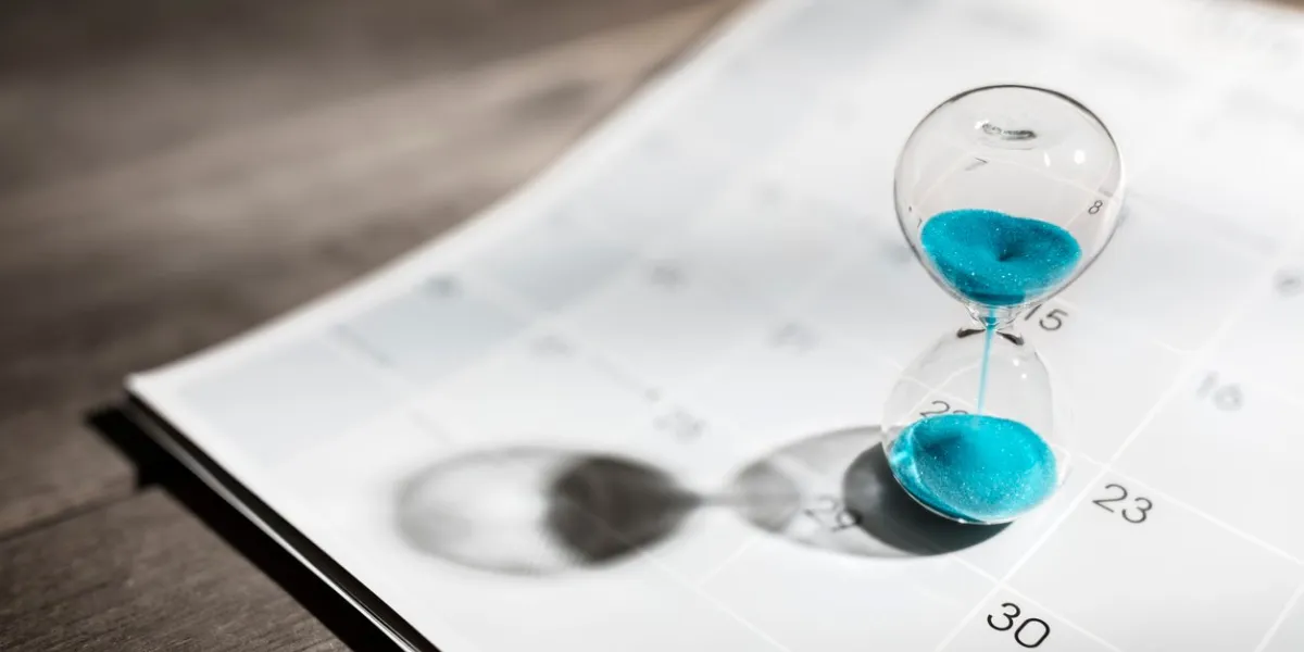 hour glass on calendar concept for time slipping away for important appointment date, schedule and deadline