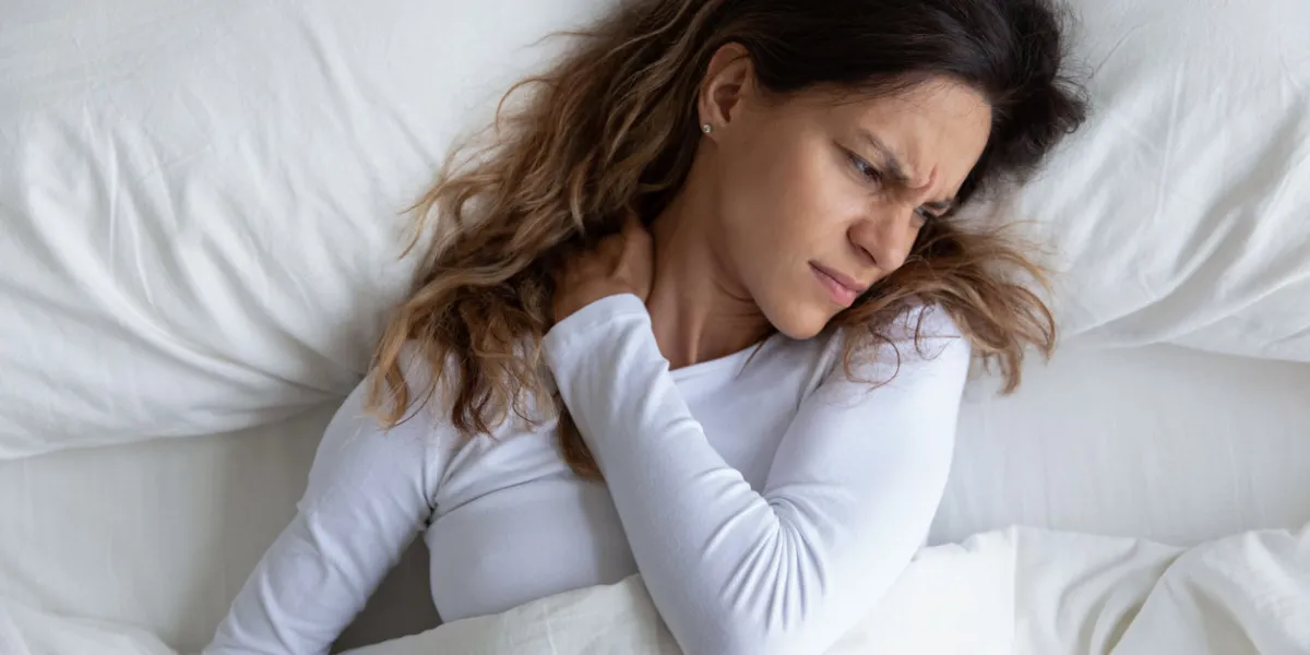 above view frown millennial woman feels pain in neck after night, awaken in bad temper having painful sudden ache or stiffness, concept of poor incorrect posture during sleeping or too soft mattress