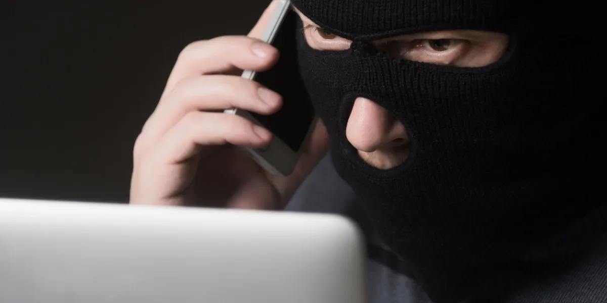 terrorist in a mask using computer for crime