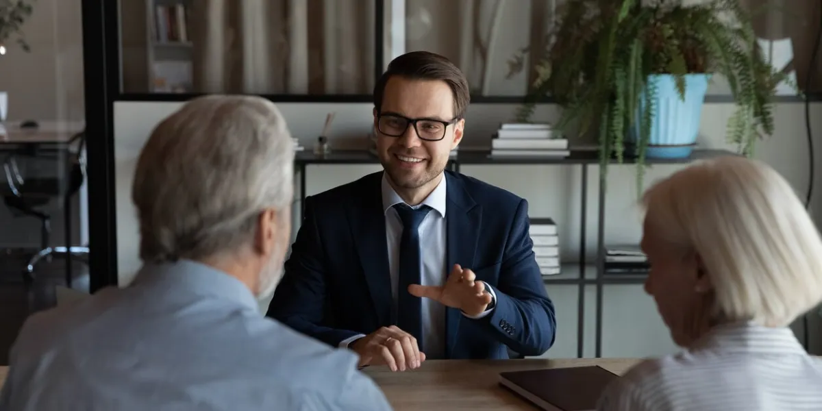 happy confident lawyer, real estate agent, notary, financial advisor giving consultation, legal advice to senior couple of clients about medical insurance, wills, house buying or selling, savings, investment