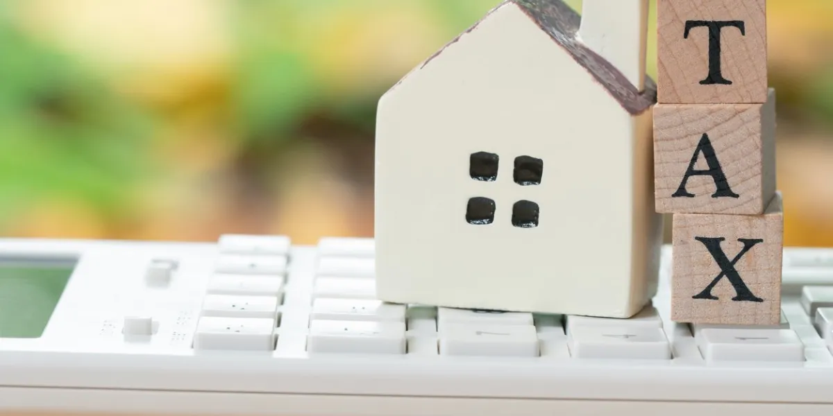 a model house model is placed on wood word tax as background property real estate concept with copy space for your text or design