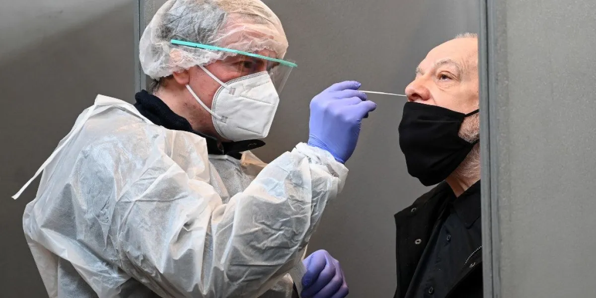 a medical worker takes a swab to test for the covid-19 from a resident in roubaix, northern france, on january 11, 2021, during a mass covid-19 testing operation (photo by denis charlet   afp)