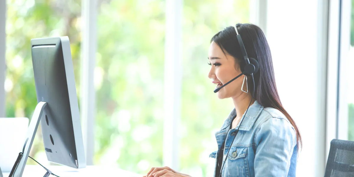 attractive business woman asian in suits and headsets are smiling while working with computer at office customer service assistant working in office