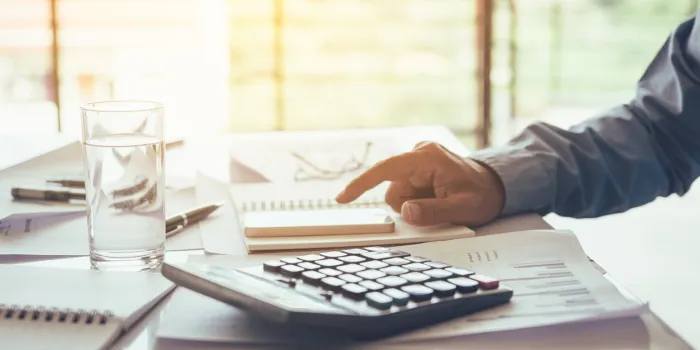 hand of businessman using smartphone looking data on table in office room