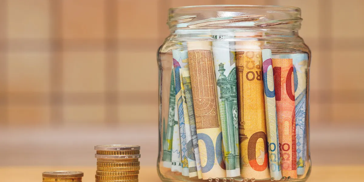 euro banknotes in a glass jar, columns of coins close-up the kitchen background is blurred the concept of finance and economics