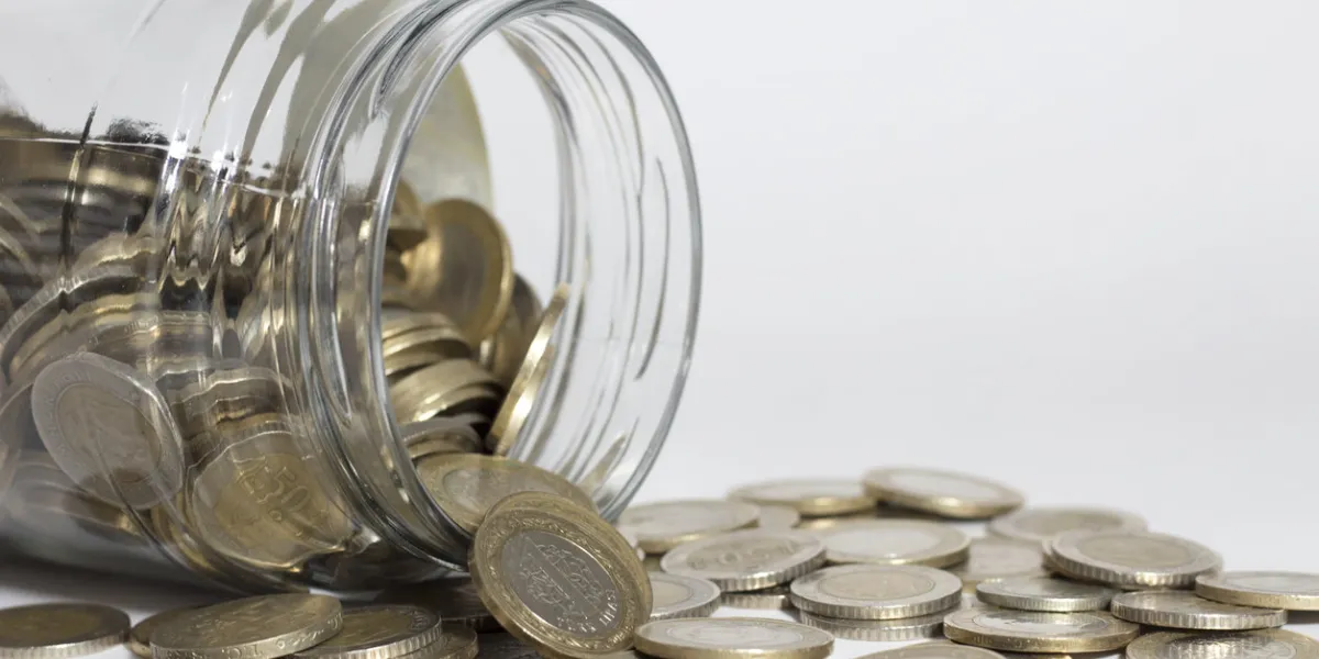 overturned glass and coins on the white background