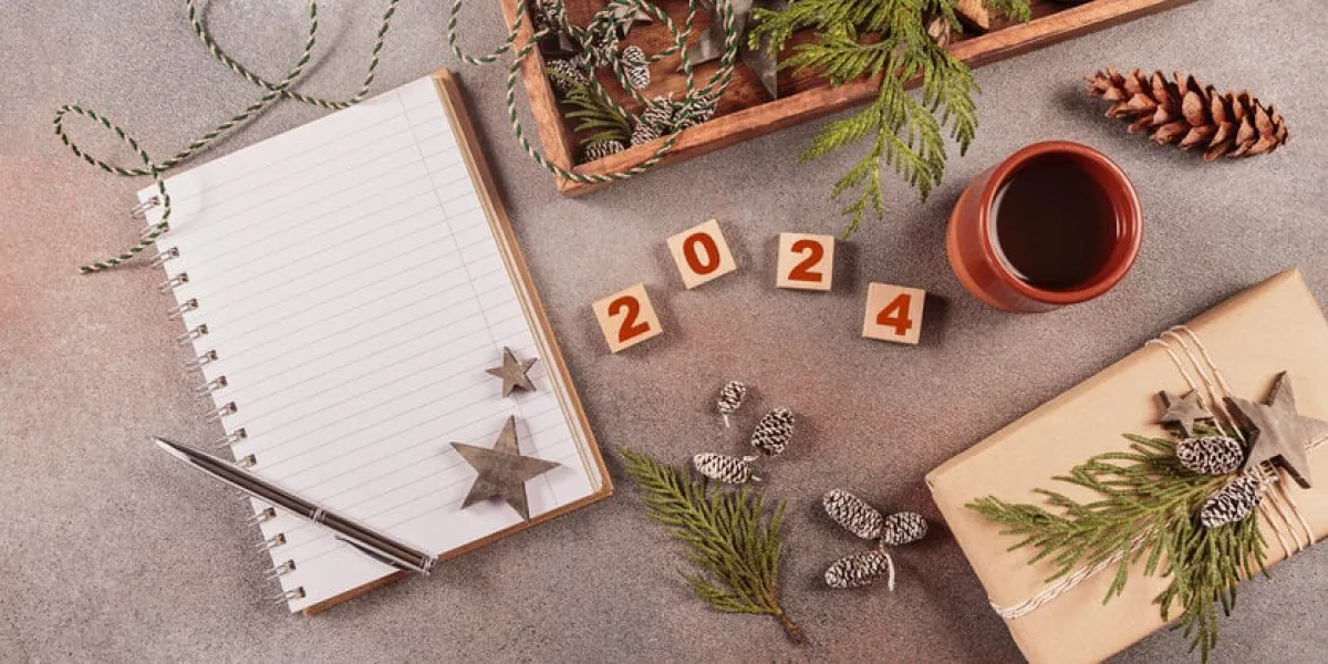 winter holiday mood, christmas, new year background preparation for holidays notebook with pen, handmade gift box, christmas wooden decor and numbers 2024 flat lay, top view