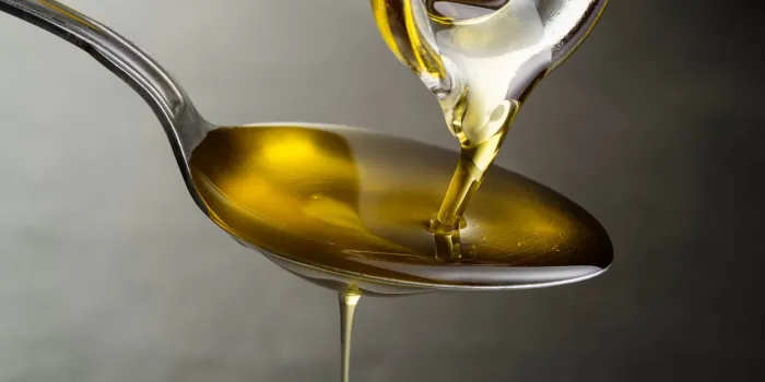 oil pouring and dripping to the spoon close up