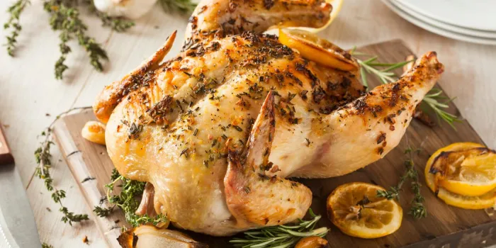 homemade lemon and herb whole chicken on a cutting board