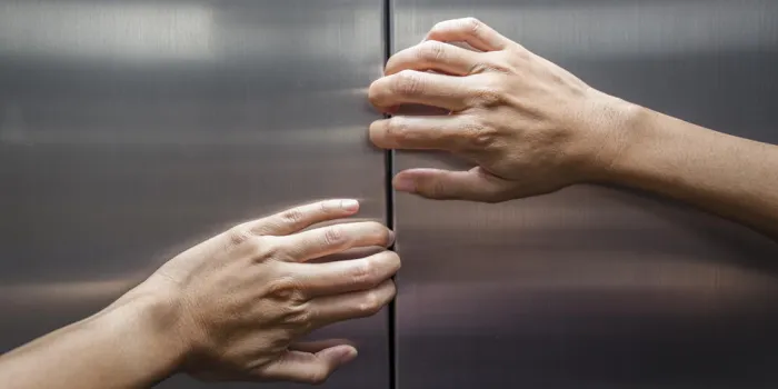 mains de femme essaient d'arrêter les portes de l'ascenseur fermé