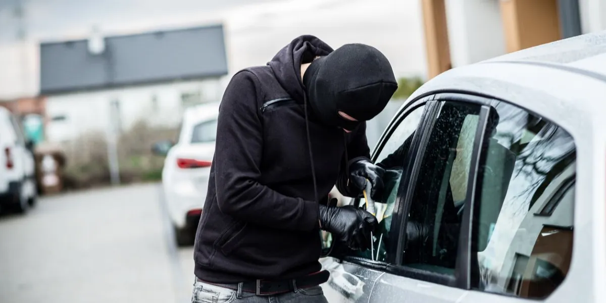 car thief trying to break into a car with a screwdriver car thief, car theft