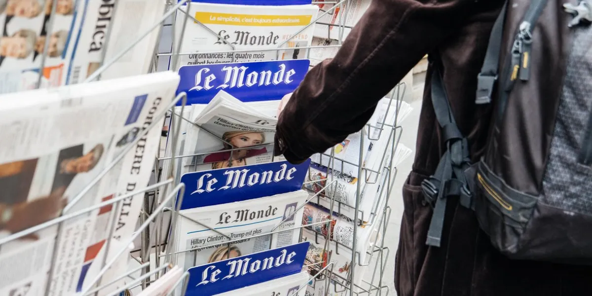 paris  man buying latest french le monde newspaper from press kiosk to read latest news scandals and journalistic investigation