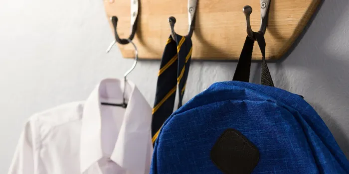 close-up of school uniform and schoolbag hanging on hook