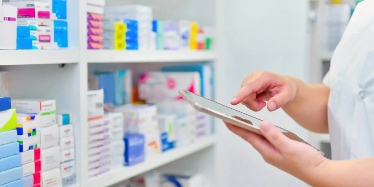 pharmacist holding computer tablet using for filling prescription in pharmacy drugstore
