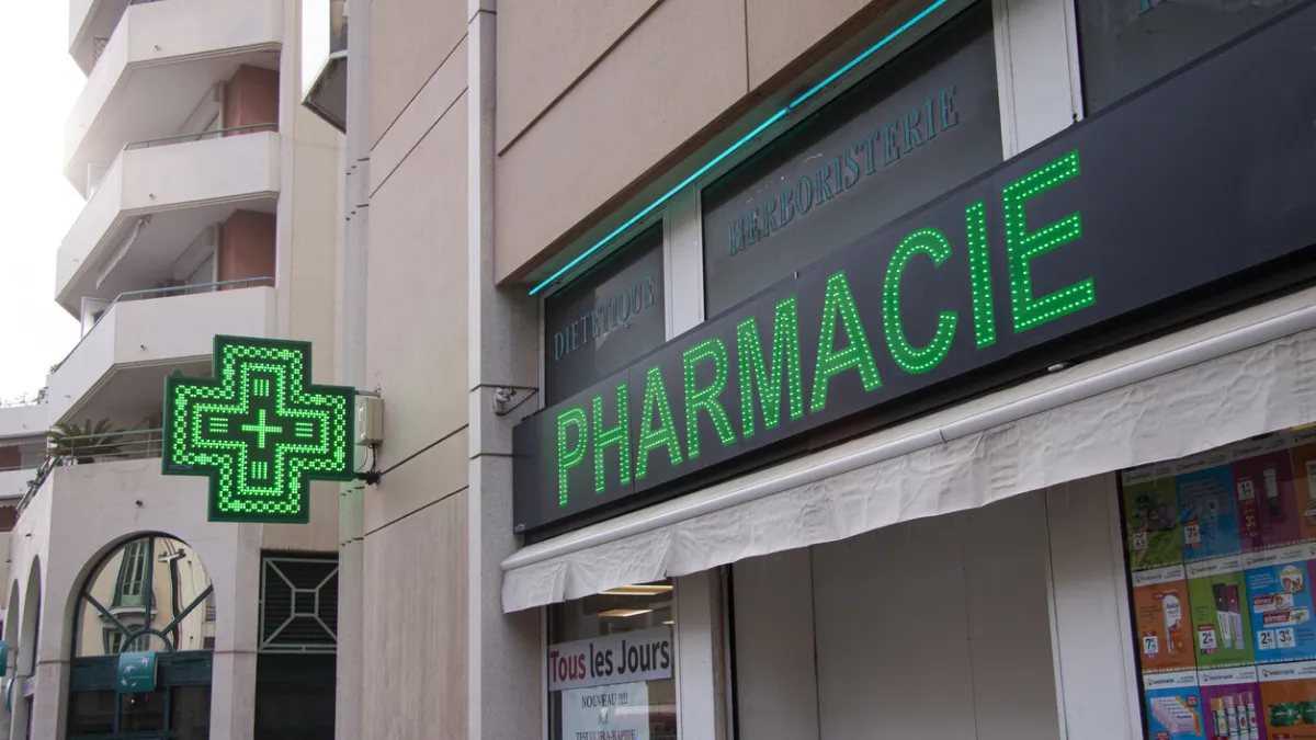 french pharmacy drug store with neon green signage - pharmacie - on front of a building nice, france - september 27