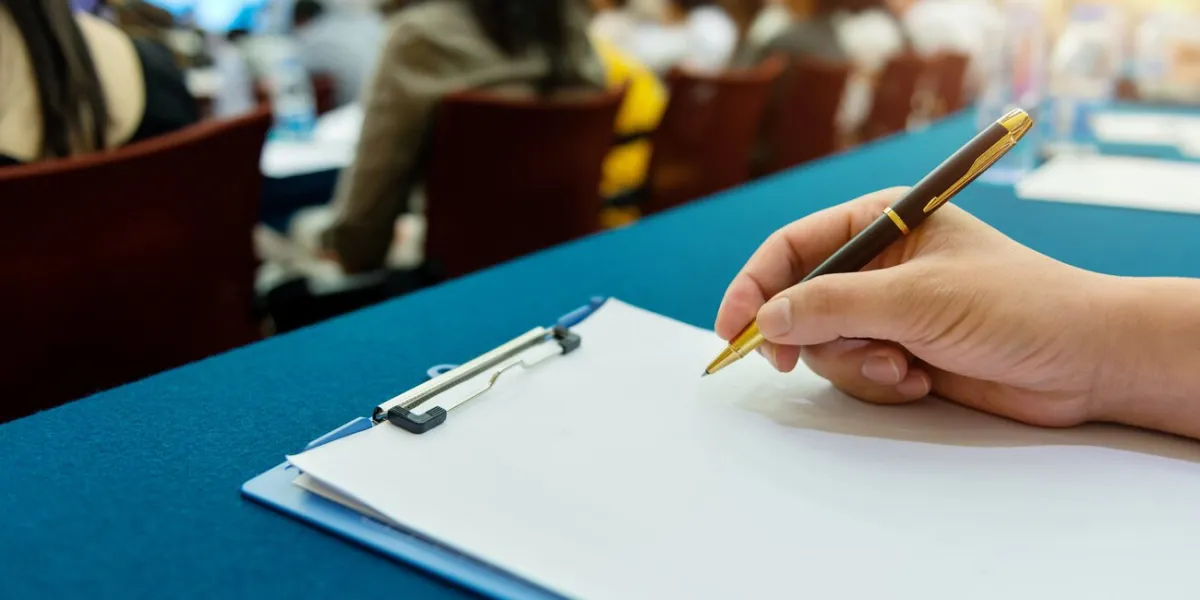 people writing on document at a business seminar