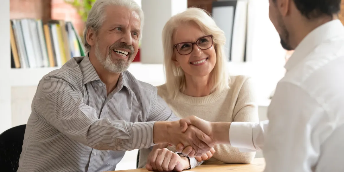 happy senior old family couple clients make financial insurance estate business deal handshake agent lawyer, satisfied mature customers shake hand meeting bank manager agree on investment contract