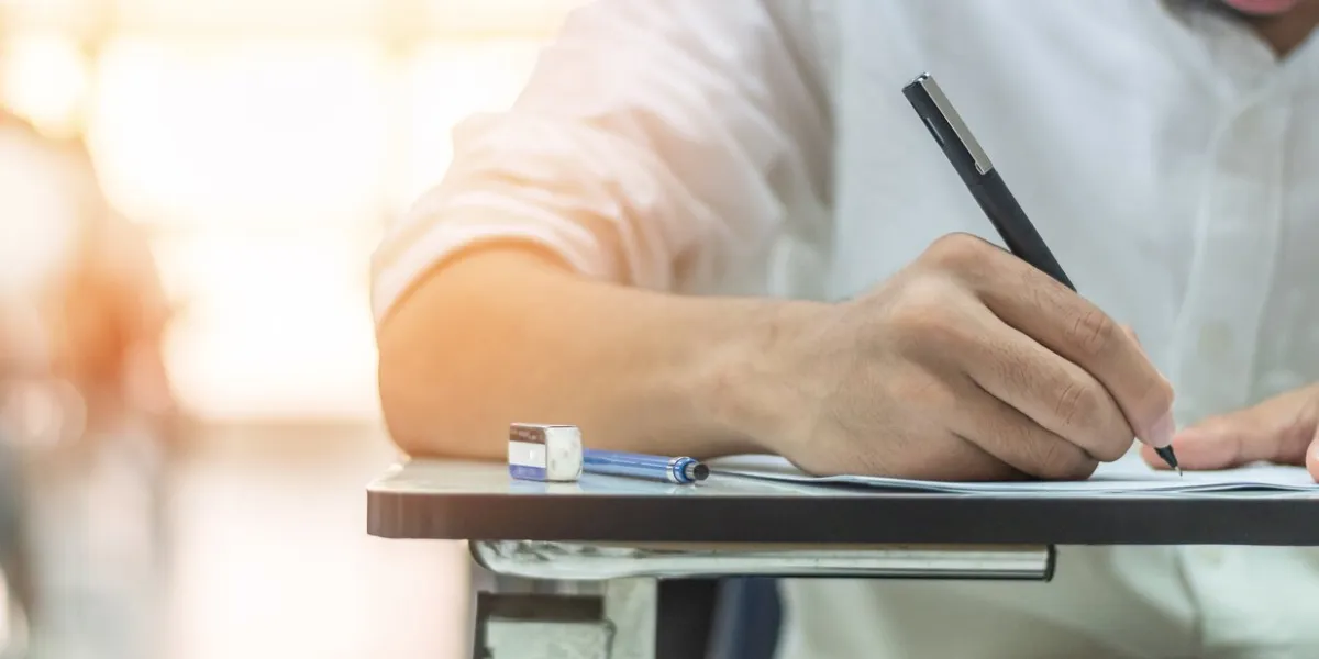 school exam student's taking educational admission test in class, thinking hard, writing answer in university classroom, education and world literacy day concept