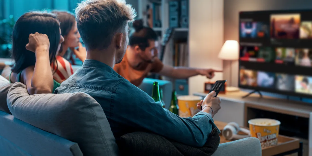 friends choosing a movie to watch together at home, video on demand concept