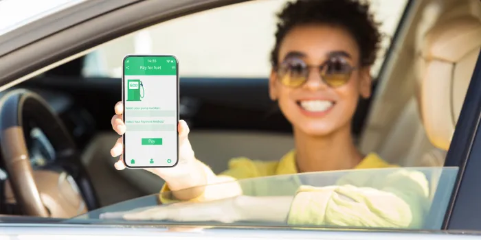 happy black woman showing smartphone with mobile app to purchase eco fuel from her car window, panorama african american lady choosing ecological petrol, making online payment, collage