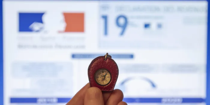 a compass in front of an income tax return and graphs with withholding tax written on them