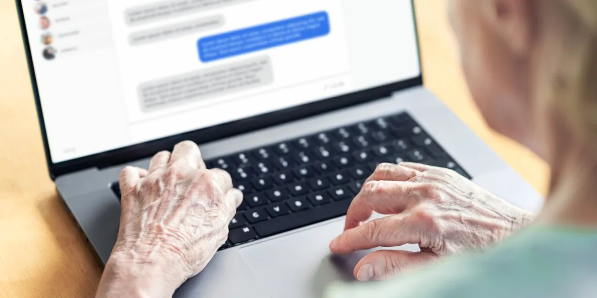 chat messages in laptop of an old woman love fraud scam of catfish elder person in online conversation with family grandma group messaging communication in social media customer support chatbot